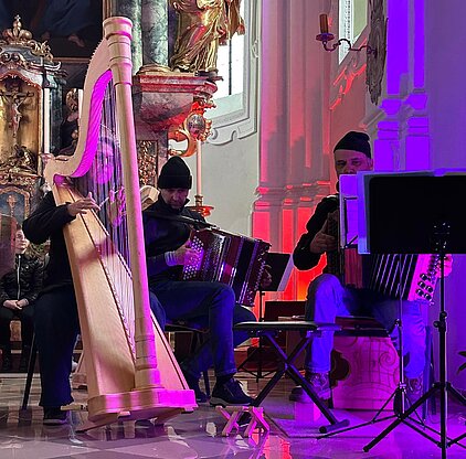 Bild mit Harfensolisin und Steirischer Harmonika solist in stimmungsvoller Atmosphäre in der Kirche