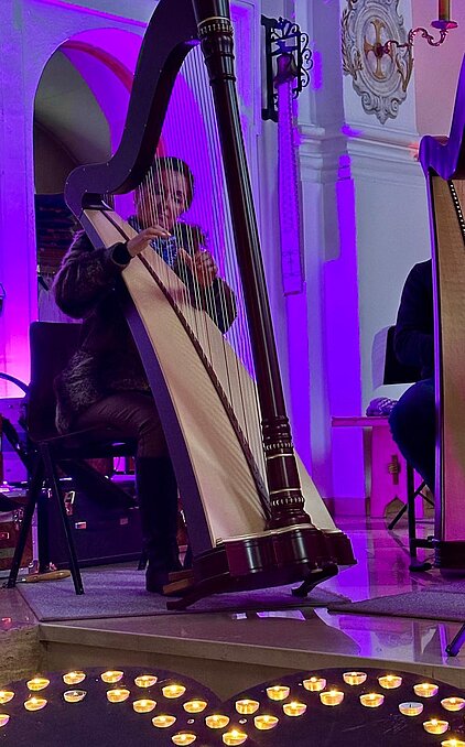 Bild mit Harfensolisin in stimmungsvoller Atmosphäre in der Kirche