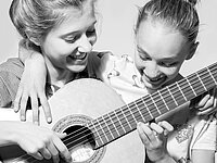 zwei Mädchen mit Gitarre