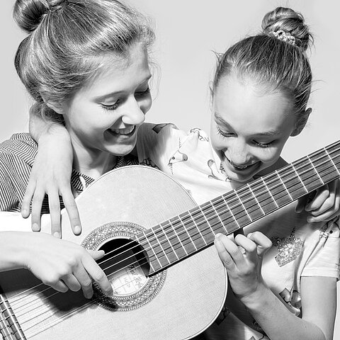 zwei Mädchen mit Gitarre