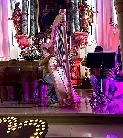 Bild mit Harfensolisin und Steirischer Harmonika solist in stimmungsvoller Atmosphäre in der Kirche