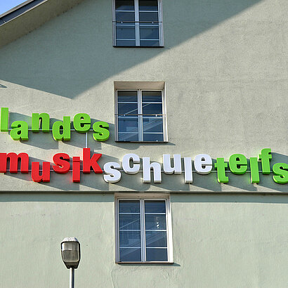 Fassade mit buntem Schriftzug Landesmusikschule Telfs
