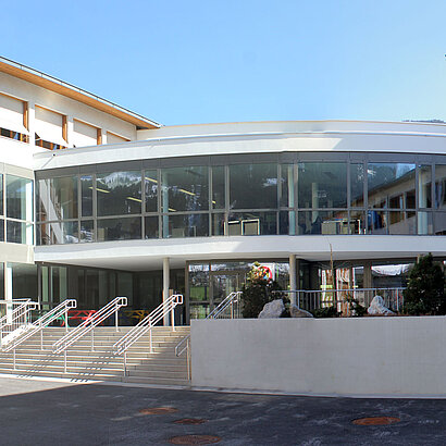 Aussenaufnahme der Landesmusikschule Kitzbühel mit moderner Glasfront