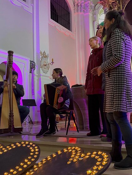 Bild mit Harfensolisin und Steirischer Harmonika solist in stimmungsvoller Atmosphäre in der Kirche