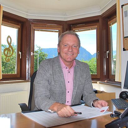 Portrait von Musikschuldirektor Gerhard Guggenbichler am Arbeitsplatz