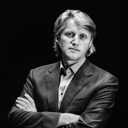 Portrait von Musikschuldirektor Peter Gasteiger mit verschränkten Armen