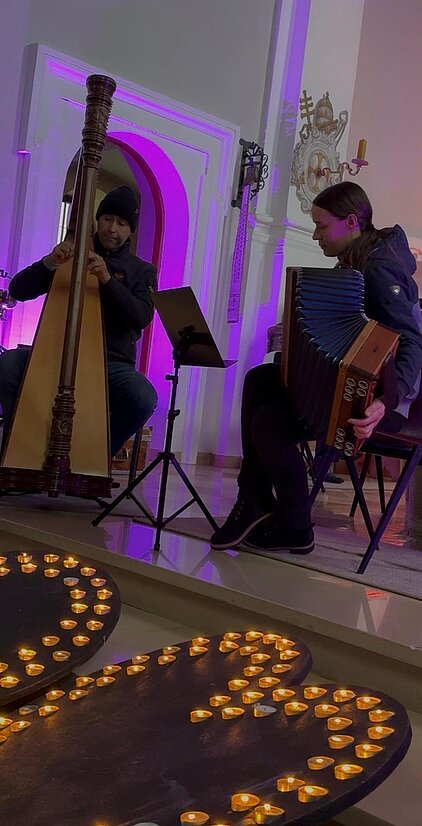 Bild mit Harfensolisin und Steirischer Harmonika solist in stimmungsvoller Atmosphäre in der Kirche